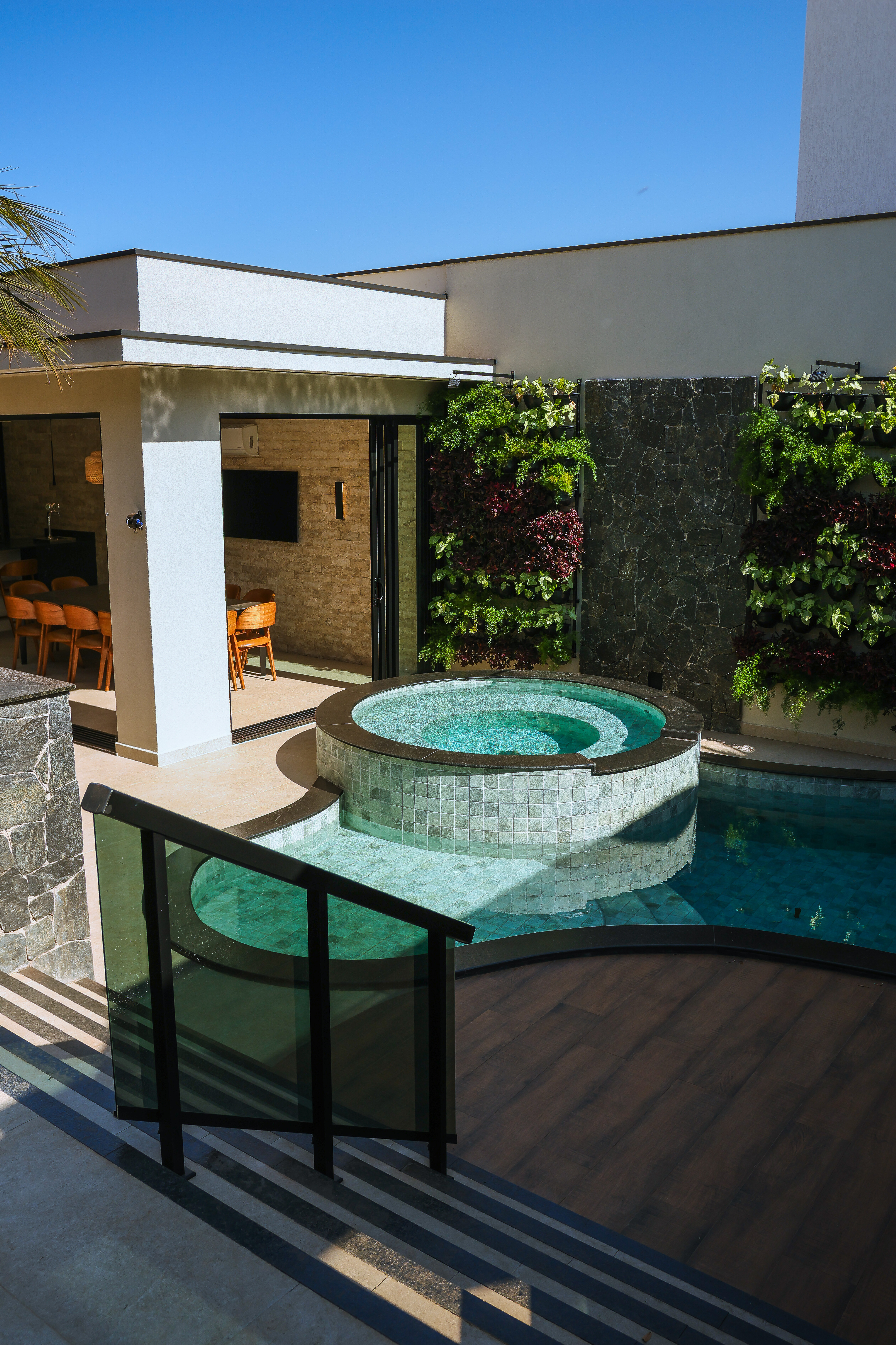 Spa elevado e piscina com guarda-corpo de vidro